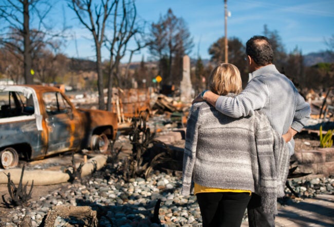 Couple staring at ruins after a fire
