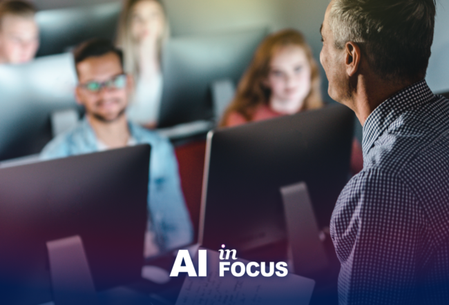 A teacher speaking to students in a computer lab showing how AI impacts education with a text overlay that reads "AI in Focus"